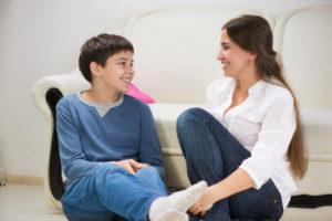 mom and teen son talking on the couch