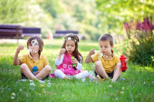 three kids blowing bubbles